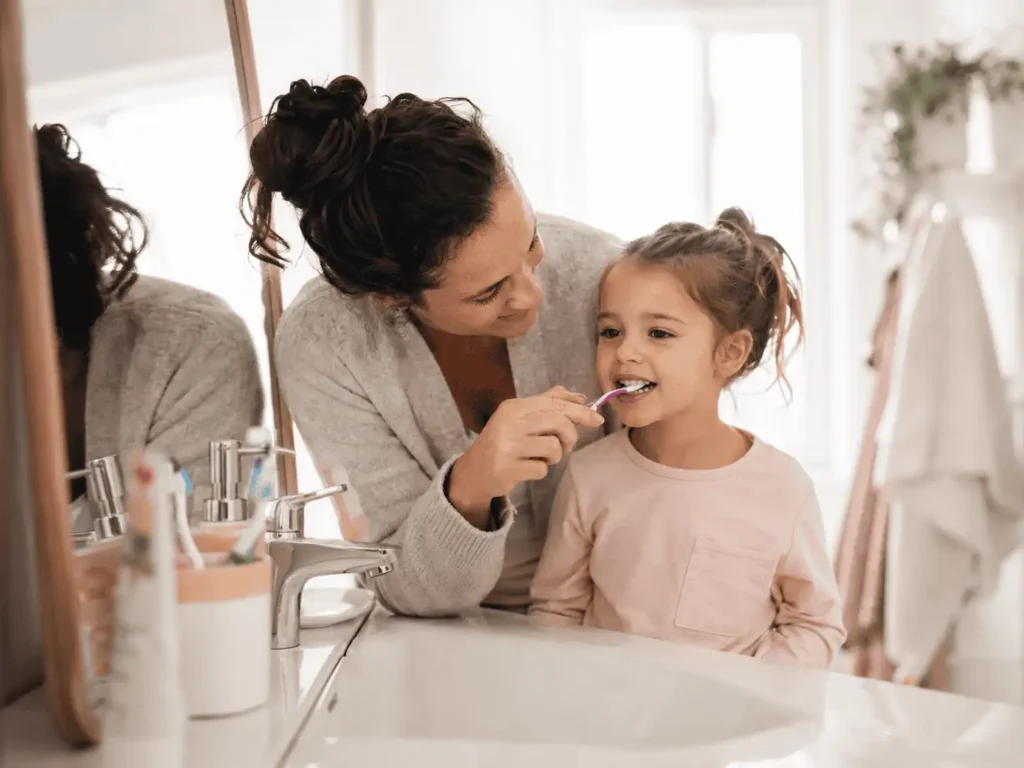 parent qui brosse les dents de son enfant - hygiène bucco-dentaire enfant