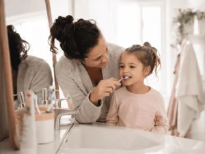 parent qui brosse les dents de son enfant - hygiène bucco-dentaire enfant